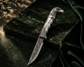 SENVIRRA Eagle Katar with sculpted silver eagle hilt held in hand, engraved blade and wood sheath resting alongside